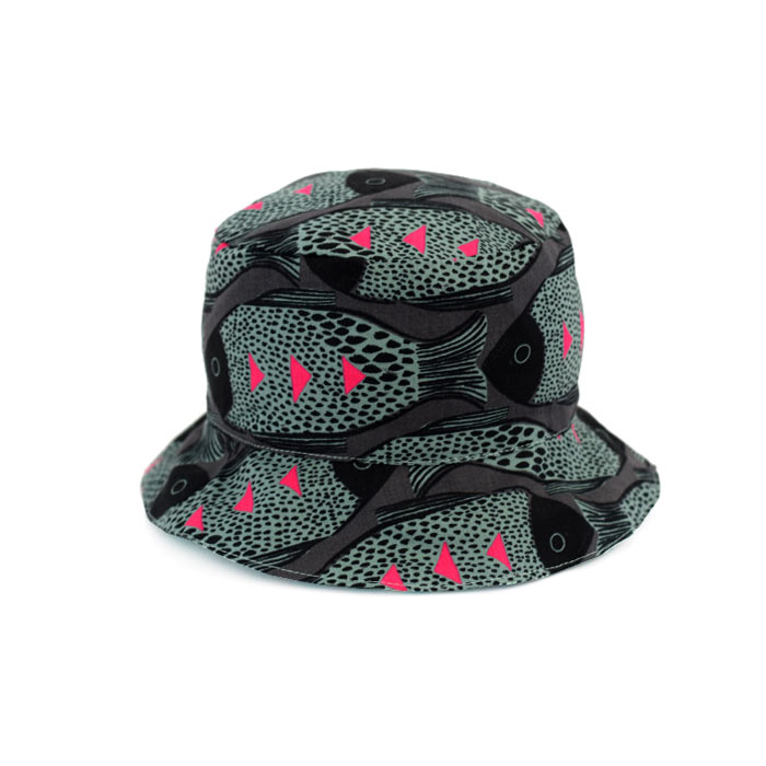 Gorro reversible Black Fish Gorro tipo pescador, en original estampado de peces en negro, gris y fucsia, por un lado y geométrico turquesa por el otro.