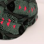 Gorra con visera y cierre con velcro. Estampado en negro y gris y detalles en fucsia