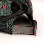 Gorra con visera y cierre con velcro. Estampado en negro y gris y detalles en fucsia