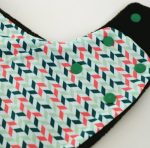 Gorro bufanda de estampado geométrico en fucsia y verde sobre blanco