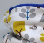 Cuello polar tipo braga con estampado de mapaches en blanco. Protege del frío a tus hijos en invierno.