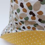 Detalle gorro reversible de motas de camuflaje